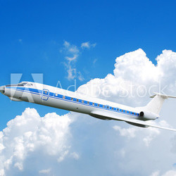 Flying jet airplane against blue cloudy sky