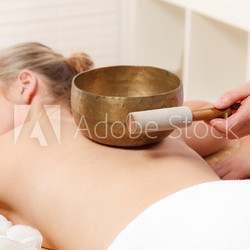 junge frau erhält eine klangschalentherapie