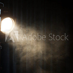 vintage theatre spot light on black curtain with smoke