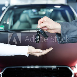 Key delivery between customer and mechanic in front of new car