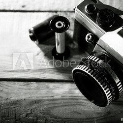 Vintage 35 mm film photo camera over wooden desk