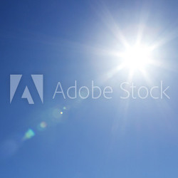 Shining sun at clear blue sky with copy space
