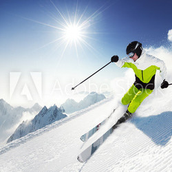 Skier in mountains, prepared piste and sunny day