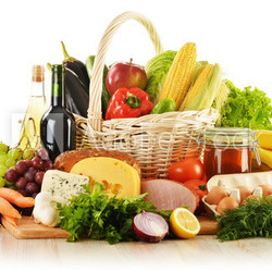 Groceries in wicker basket isolated on white