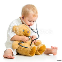 Adorable child with clothes of doctor and teddy bear over white