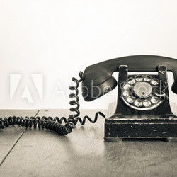 Vintage telephone on old table sepia photo