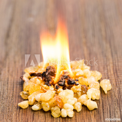 Brennender Weihrauch mit Flamme auf Holz