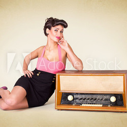 Pinup Mädchen liegt neben altem Radio