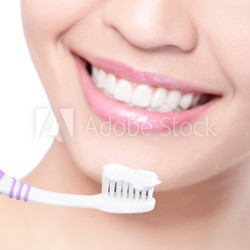 smiling woman cleaning teeth with toothbrush