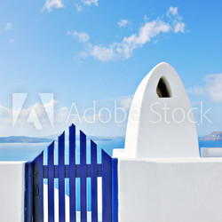 Traditional greek gate and chimney overlooking the caldera in Oi