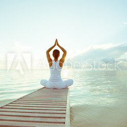 Caucasian woman practicing yoga at seashore