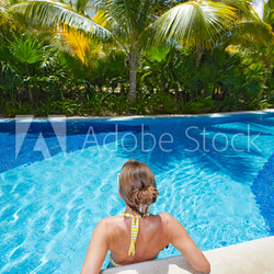 Woman in swimming pool at caribbean resort.