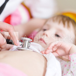Pediatric doctor exams little girl with stethoscope