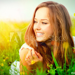 Beauty Girl in the Meadow lying on Green Grass