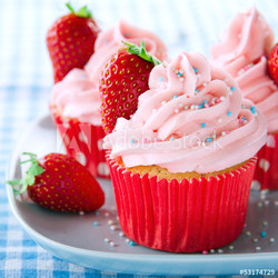 Pink cupcakes with fresh strawberries and sprinkles