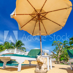 Tropical scenery with parasol and deck chairs in Thailand