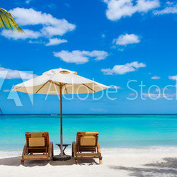 two deckchairs on the idyllic white beach in front of the turquo