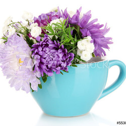 Beautiful bouquet of bright flowers in color mug, isolated