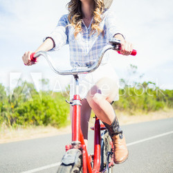 Cheerful trendy woman posing while riding bike