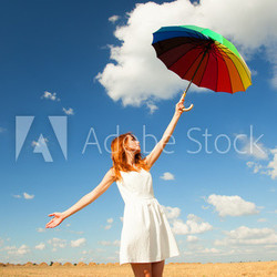 Redhead girl with umbrella at field