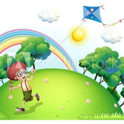 A boy playing with his kite at the hilltop