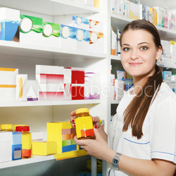 Pharmacist holding out tablets in bottle at drugstore