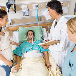 Doctor And Nurse With Woman Looking At Critical Patient