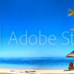 Tropical beach panorama with chairs and umbrellas