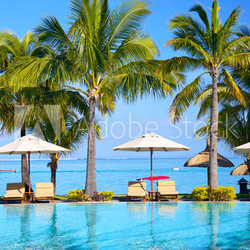 Swimming pool with  umbrellas on beach in Mauritius
