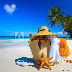 Art Straw hat, bag, sun glasses and flip flops on a tropical bea